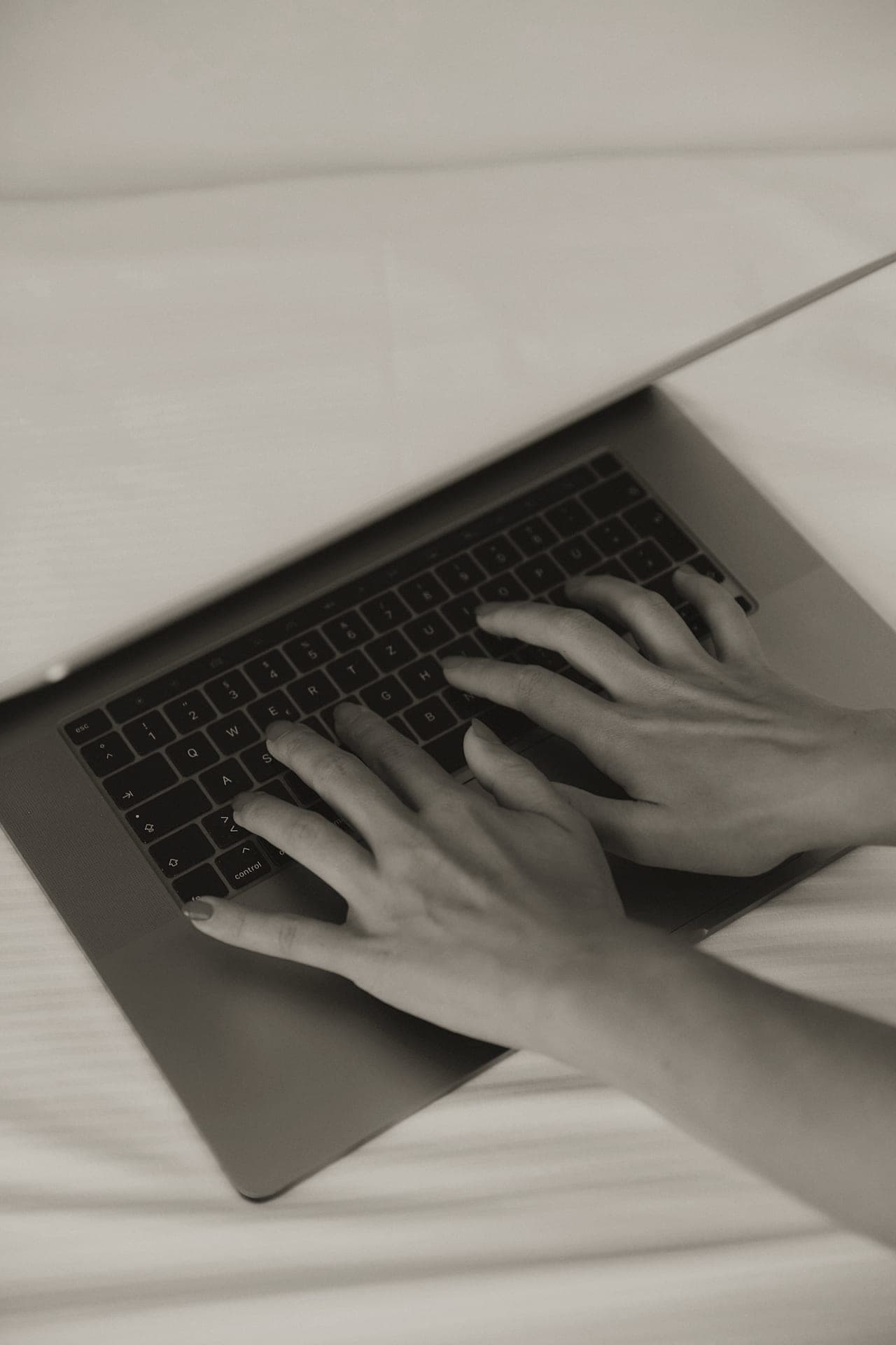A pair of hands at a keyboard, mid-sentence.